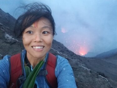 Person sming in front of volcano