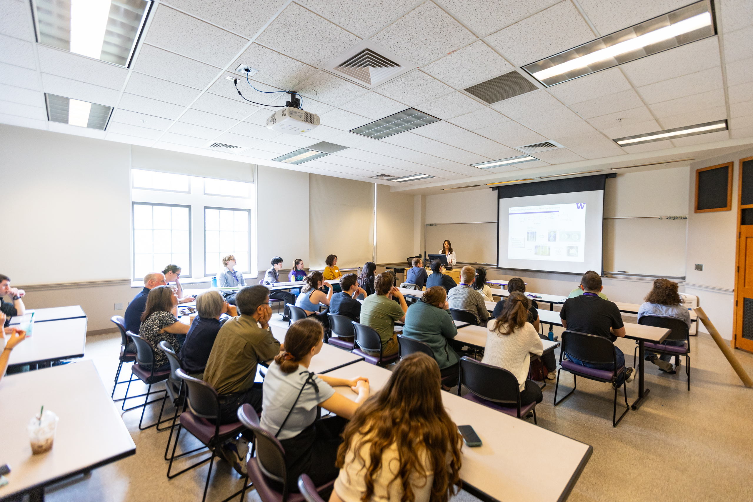 students in a classroom facing instructor and projection screen