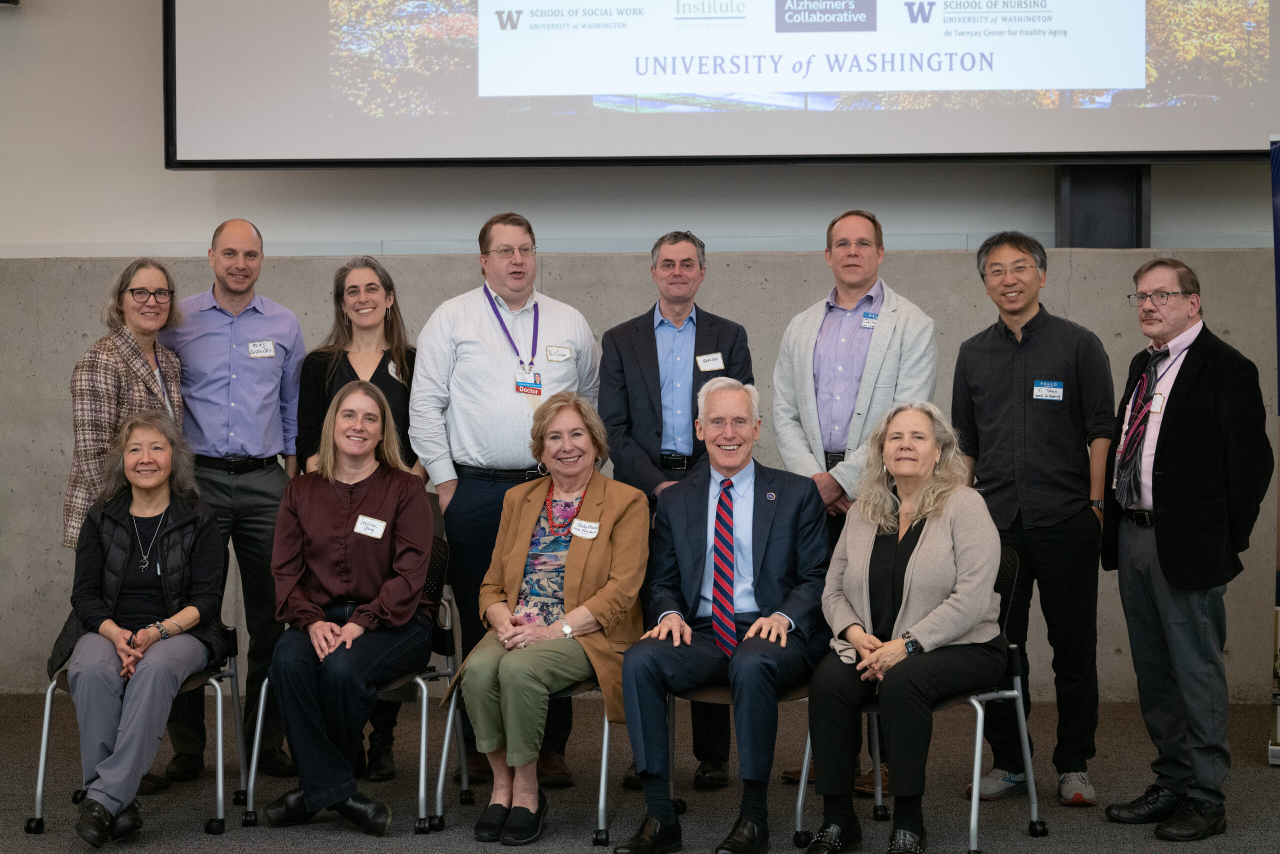 faculty standing and sitting smiling at camera