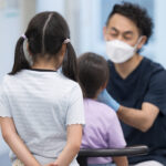 children waiting to get their temperature taken
