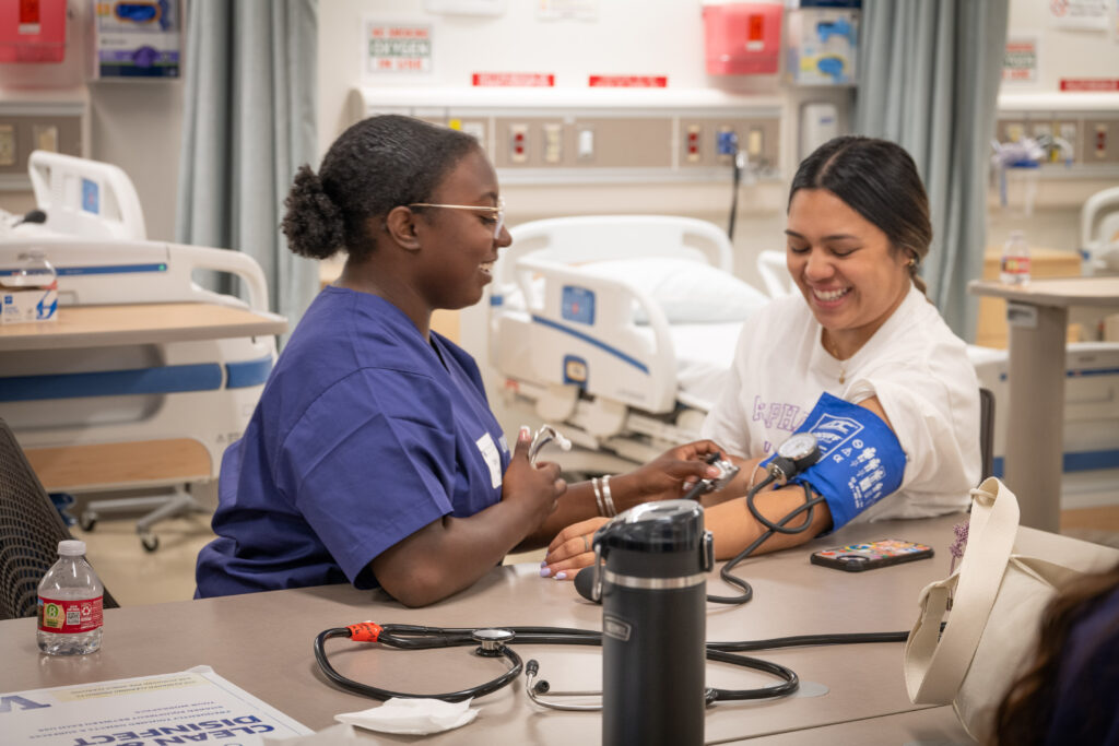 Two students practice taking blood pressure in a UW School of Nursing simulation lab