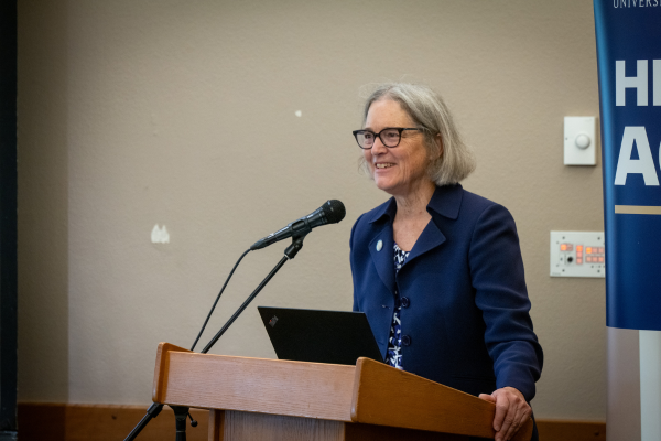 Basia Belza standing at a podium
