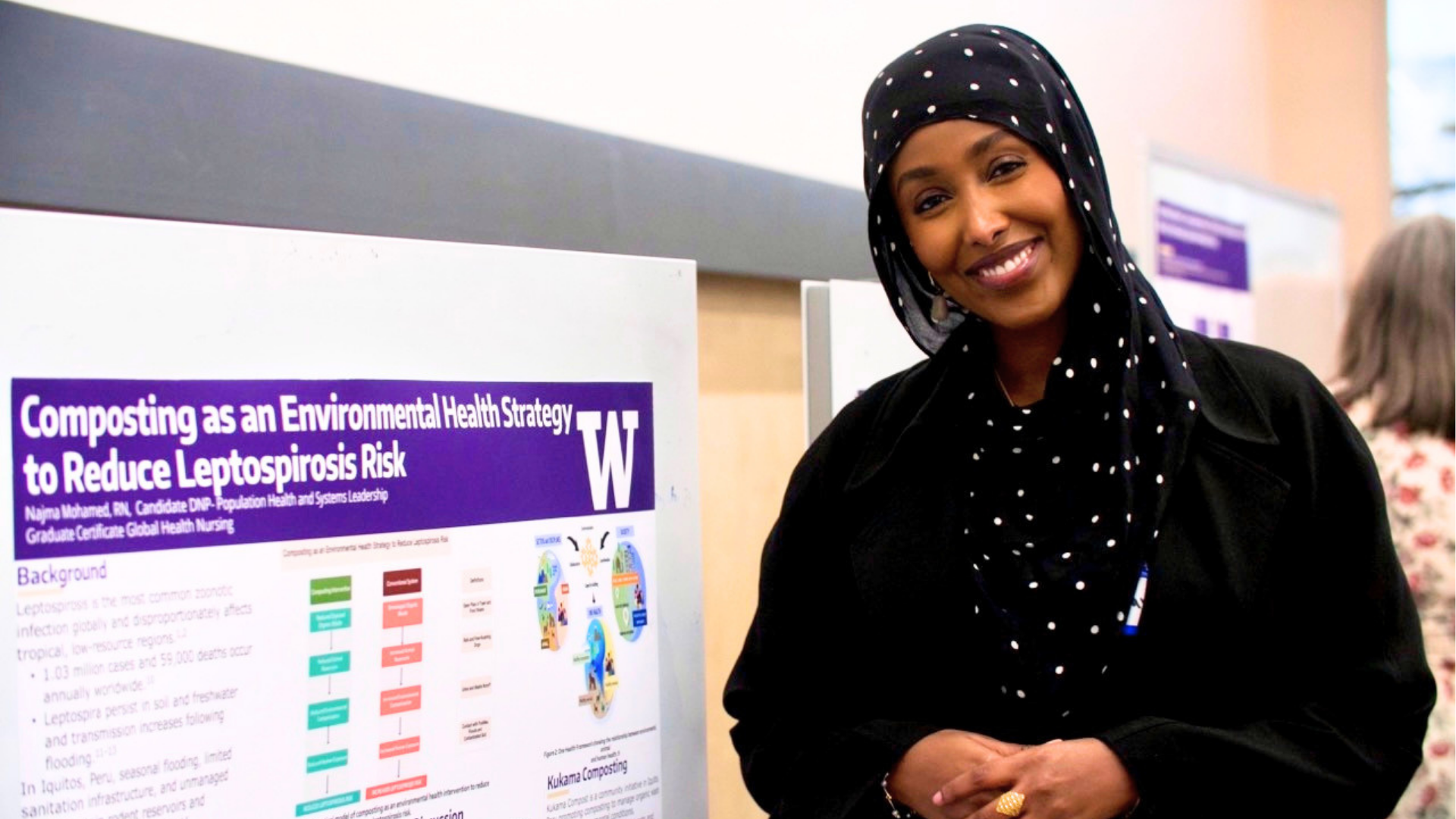 A student standing in front of her research paper.