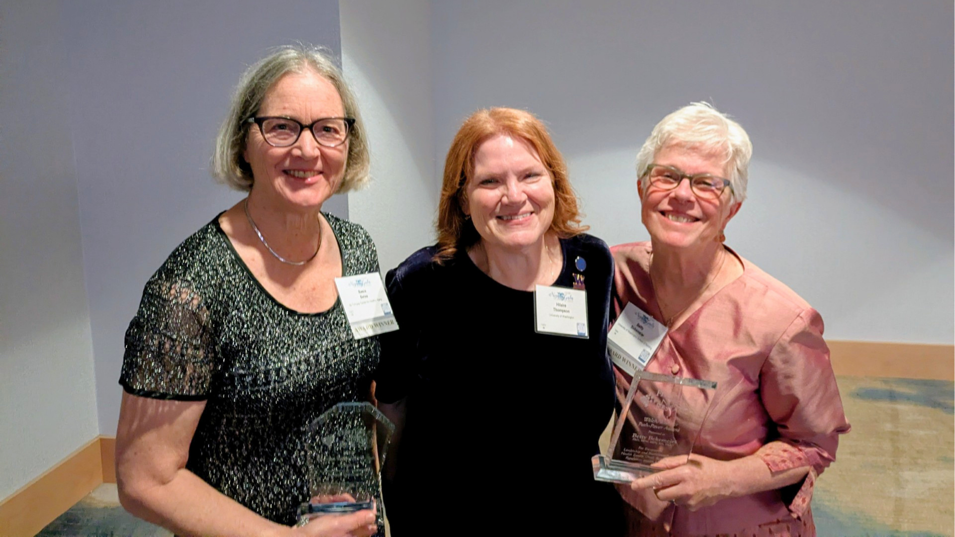 Three women smiling and looking directly at the camera.