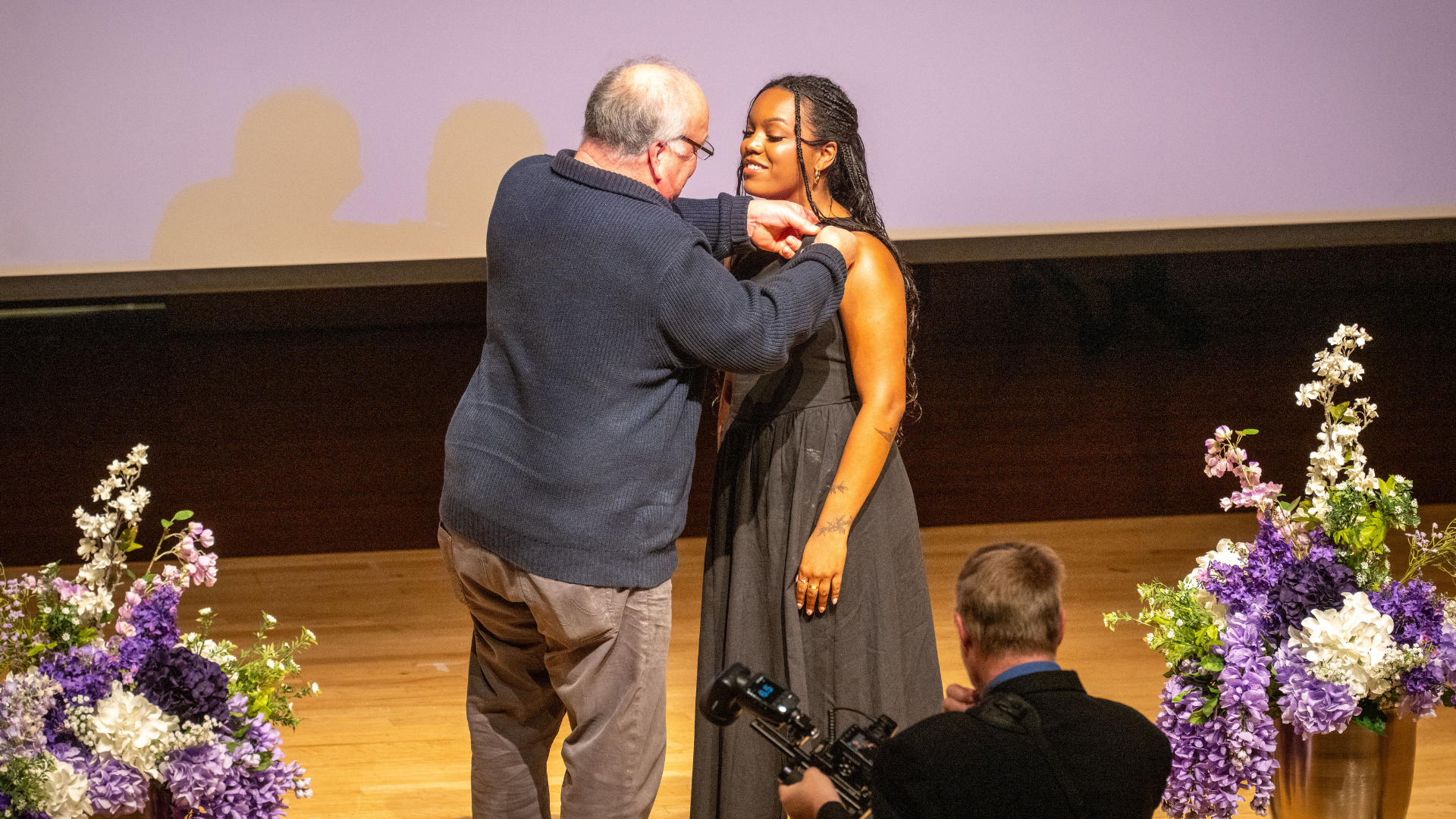 A student getting a pin pinned to her dress at a pinning ceremony.