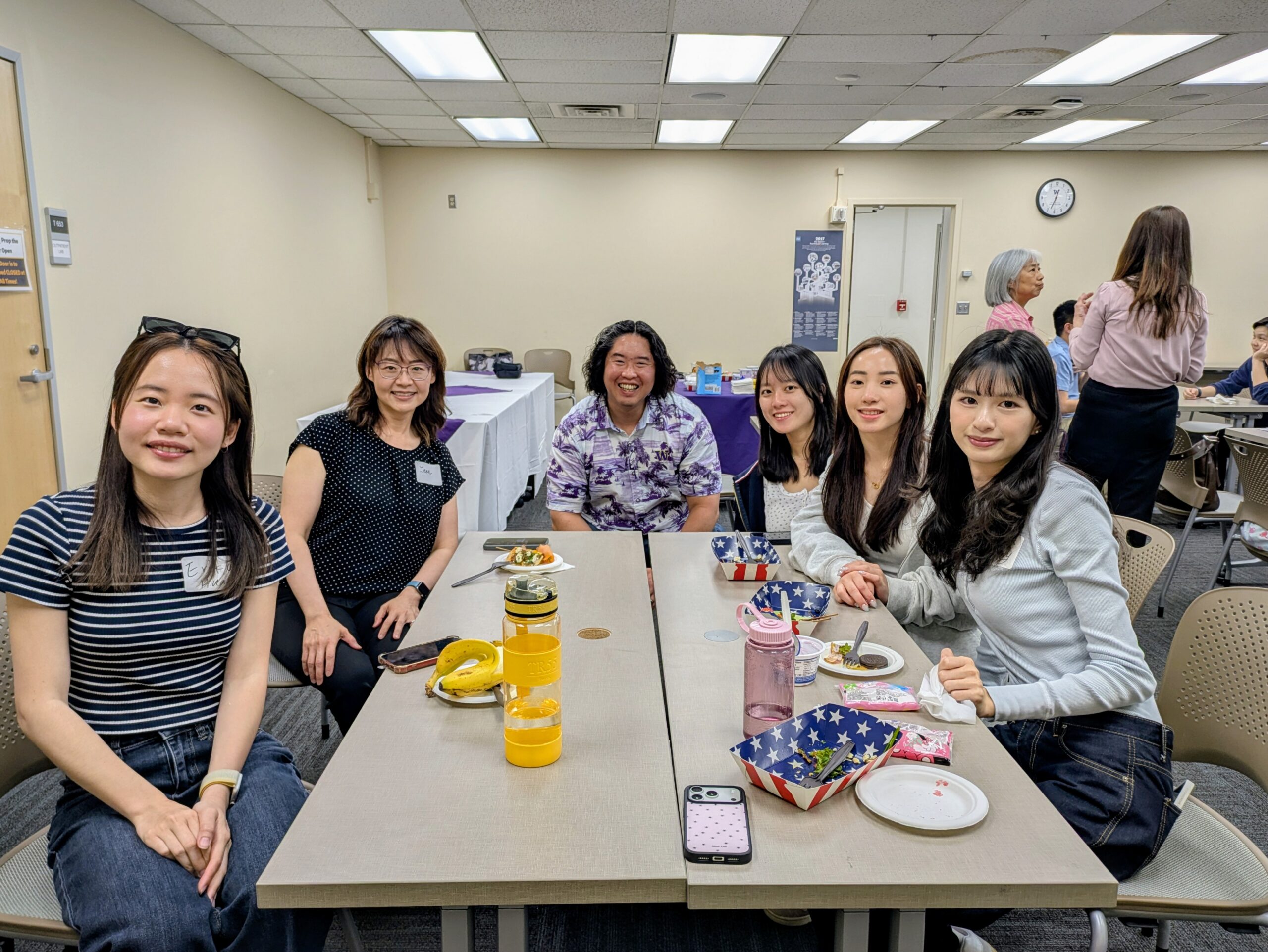 Group with food sitting at a table and smiling at the camera