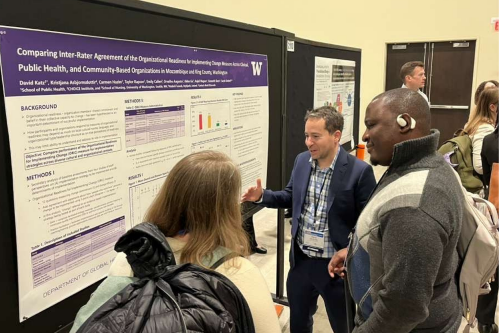 Conference attendees discuss a University of Washington research poster during a poster presentation session.