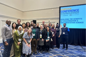 Conference attendees gather for a group photo at the 18th Annual Conference on the Science of Dissemination and Implementation in Health.