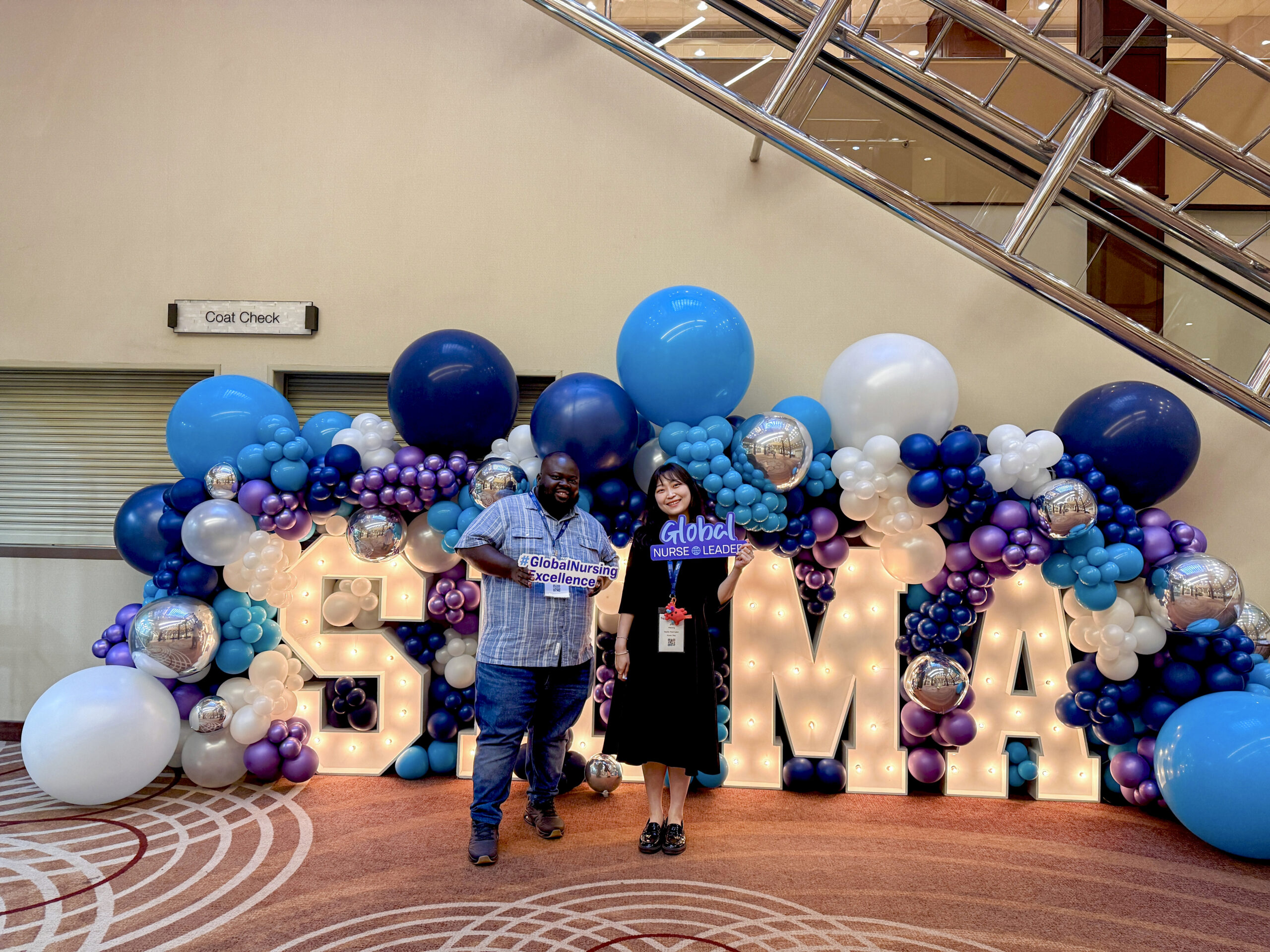 Two students posing with global nursing decorations